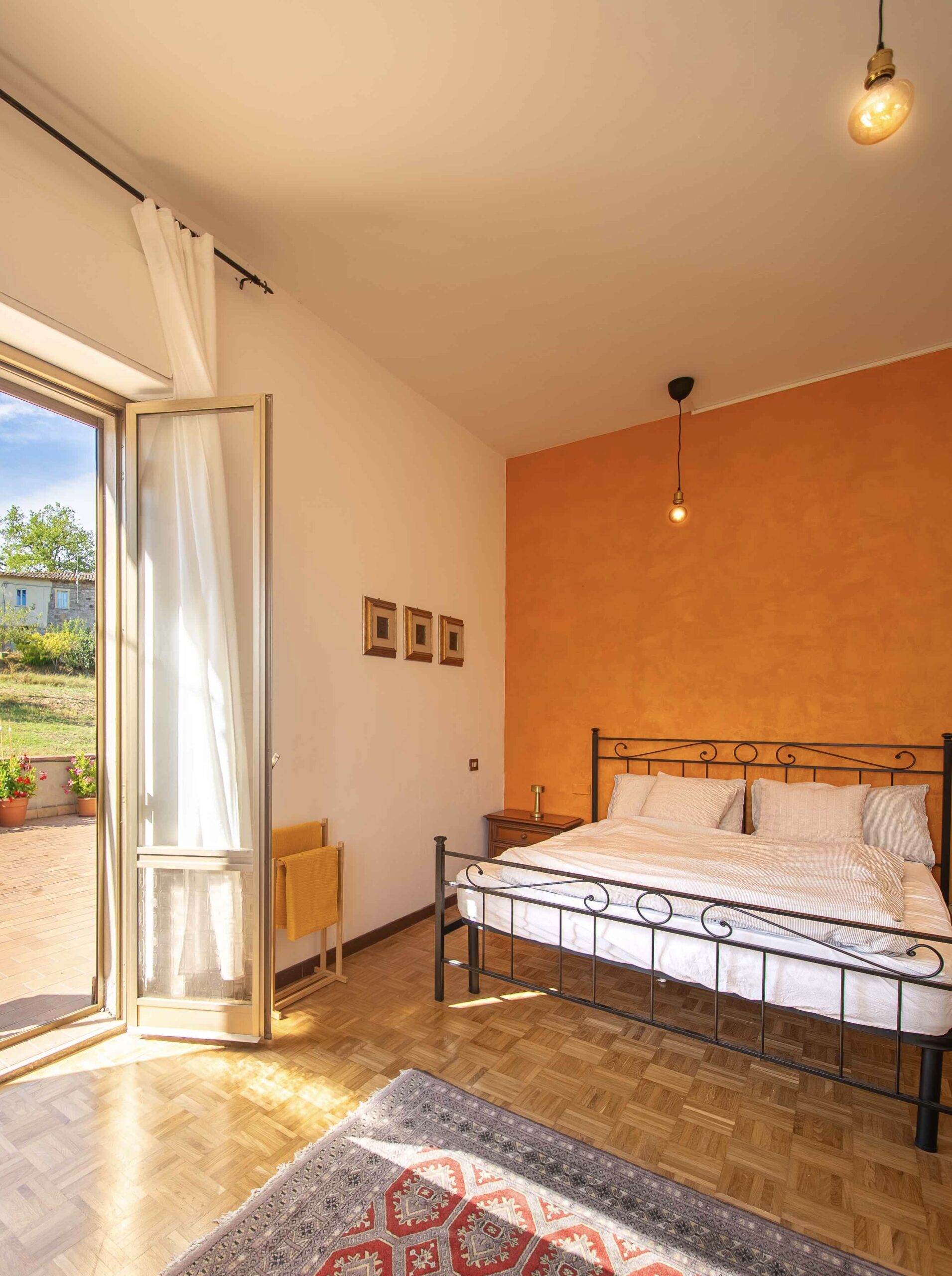 Bright bedroom with an open door to a sunny terrace at Casa Burnie.
